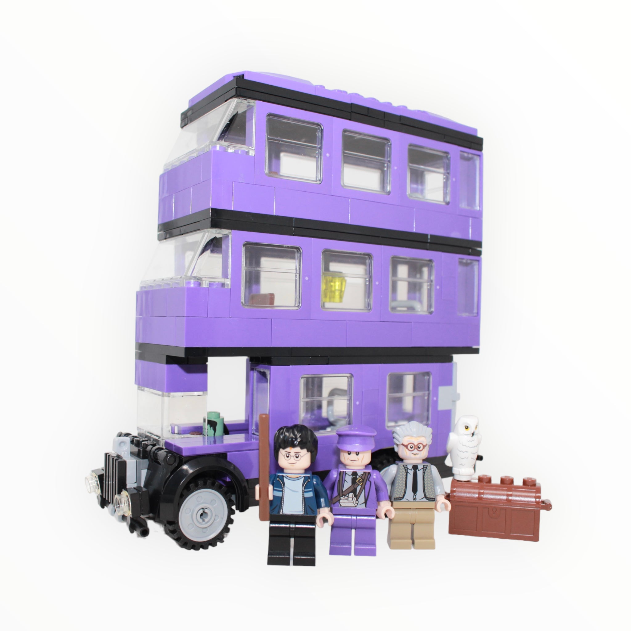a purple double decker bus parked in front of a building 